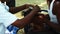 A South Asia boy crying gets his head shaved at temple car festival function