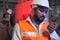 South Asia male factory worker or Man engineer or expert staff wear safety vest and helmet holding Walkie Talkie