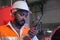 South Asia male factory worker or Man engineer or expert staff wear safety vest and helmet holding Walkie Talkie