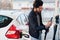 South asian man or indian male refueling his white car on gas station and pay by mobile phone