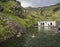 South Iceland, Seljavellir, July 4, 2018: People swimming and enjoying green warm water in Seljavallalaug secret geothermal pool h