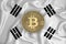 South Korea flag, bitcoin gold coin on flag background. The concept of blockchain, bitcoin, currency decentralization in the