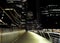 The South Quay Footbridge To The Brightly Lit Bank Towers Of Canary Wharf  London England At Night