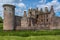 South side of Caerlaverock Castle under blue sky, Scotland UK.