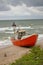 Souther Baltic sea coast, Northern Poland, Pomerania, sandy beach, dramatic sky, late winter time, fishing boat on the sand