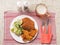 Southern fried chicken fillet meal with green fresh salad and fancy cut potato chips served on white plate and glass of lager beer