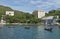 Southern port area, ship and boat parking in a bay, buildings, coastline, amidst tropical greenery, blue sky and clouds, Vietnam