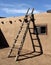 Southwestern ladder leaning against adobe wall in Taos Pueblo