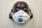 Souvenir mask of a laughing Buddha in a respirator