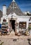 Souvenir shop in traditional white trulli house with conical roofs and painted symbols in Alberobello