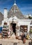 Souvenir shop in traditional white trulli house with conical roofs and painted symbols in Alberobello, Apulia