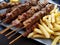 Souvlaki or souvlakia greek ethnic food from roasted meat plate with potatoes and lemon