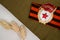 Soviet Bage Â«GuardÂ» and St. George ribbon, dried flowers and bullet on craft background