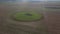 The sowed and cleaned agriculture fields. Aerial lockdown shot of field with barn in middle.