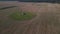 The sowed and cleaned agriculture fields. Aerial lockdown shot of field with barn in middle.