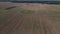 The sowed and cleaned agriculture fields. Aerial lockdown shot of field with barn in middle.