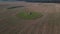 The sowed and cleaned agriculture fields. Aerial lockdown shot of field with barn in middle.