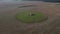 The sowed and cleaned agriculture fields. Aerial lockdown shot of field with barn in middle.