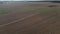 The sowed and cleaned agriculture fields. Aerial lockdown shot of field with barn in middle.