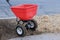 Sowing lawn grass seeds with a drop lawn spreader in the residential backyard
