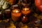 Soy candles burn in glass jars. Tree leaves, pumpkin. Comfort at home. Candle in a brown jar. Scent and light. Scented