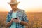 Soybean farmer text messaging on mobile phone from field