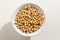 Soybean legume. Top view of grains in a bowl. White background