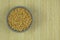 Soybeans in bowl on a straw background. Protein pulse that is dried and then soaked and cooked before eating. Vegetarian product.