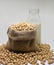 Soybeans in hemp sack bag on white background.