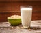 Soybeans and soy milk in a glass on wood background