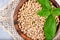 Soybeans in wooden bowl on light background