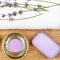 SPA accessories: lavender soap, scented candle, dried lavender flowers and a towel on a wooden