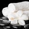 Spa background of white hibiscus flower and towels on zen basalt