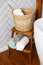 Spa and bath cosmetics, basket with towel rolls in rustic interior.