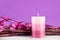 Spa composition with aromatic candle and purple flowers and branches on desk