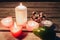 Spa composition of candles towels, flowers and avocado on wooden table.