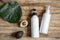 Spa composition with dispenser bottles, avocado fruit and leaf on wooden surface top view