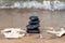 Spa composition - stacked Basalt Stones, Seashells and Sea Stars on the beach at sunrise in front of the ocean.