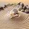 Spa composition with stones and flower on yellow sand, shallow depth focus. Spa stones and white flower on sand with creative