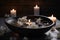 Spa concept. Bowl of water, floating flower petals, lit candles and stones