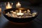 Spa concept. Bowl of water, floating flower petals, lit candles and stones