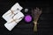 Spa concept. Lavender salt for a relaxing bath, aroma oil, white towels and dry lavender flowers on a black wooden background.