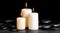 Spa concept of white candles on zen basalt stones with drops