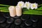 spa concept of zen basalt stones, three white flower frangipani, candles and natural bamboo with dew, closeup
