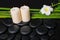 spa concept of zen basalt stones, white flower frangipani, candles and natural bamboo with dew, closeup