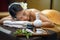 Spa concept, Zen stones, Candles and flowers on the background of woman receiving treatment, Young beautiful woman in spa