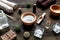 Spa cosmetics with soap, salt, oil, towels, candles on wooden background