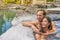 Spa couple luxury wellness retreat resort relaxing in hot tub at luxury hotel. Happy Asian woman and Caucasian man at