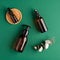 SPA natural organic cosmetic set. Amber glass bottles and eucalyptus leaf on green background. Flat lay, top view. Skin care