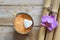 Spa set on wooden table, coconut and bath salt, flower of orchids and white stone in the shape of a heart, natural bamboo.